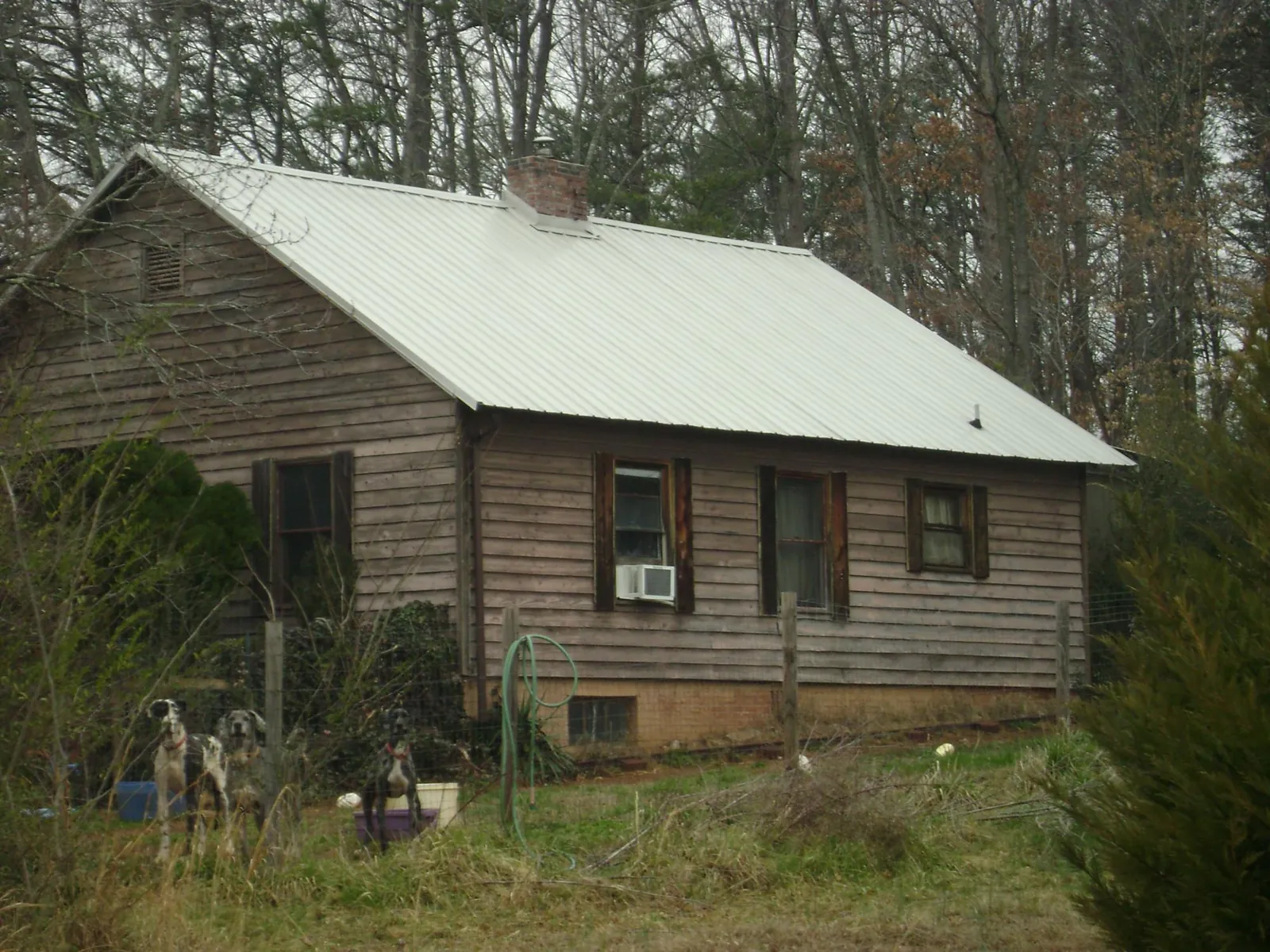 White metal roof on an old wood sided farmhouse, from a Metal Roof Installation job in Clifton